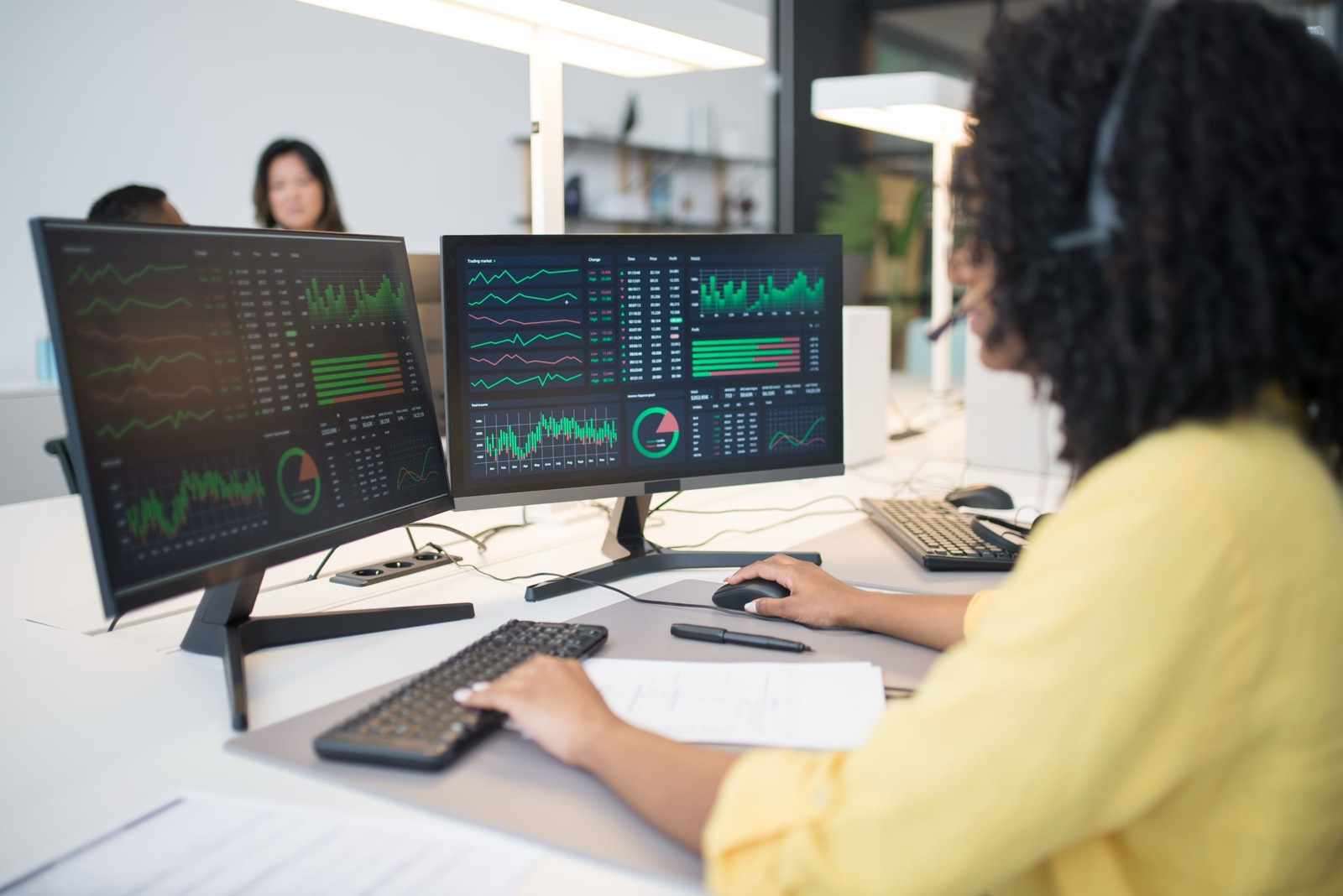 A financial analyst at a desk of trading and reconciliation dashboards
