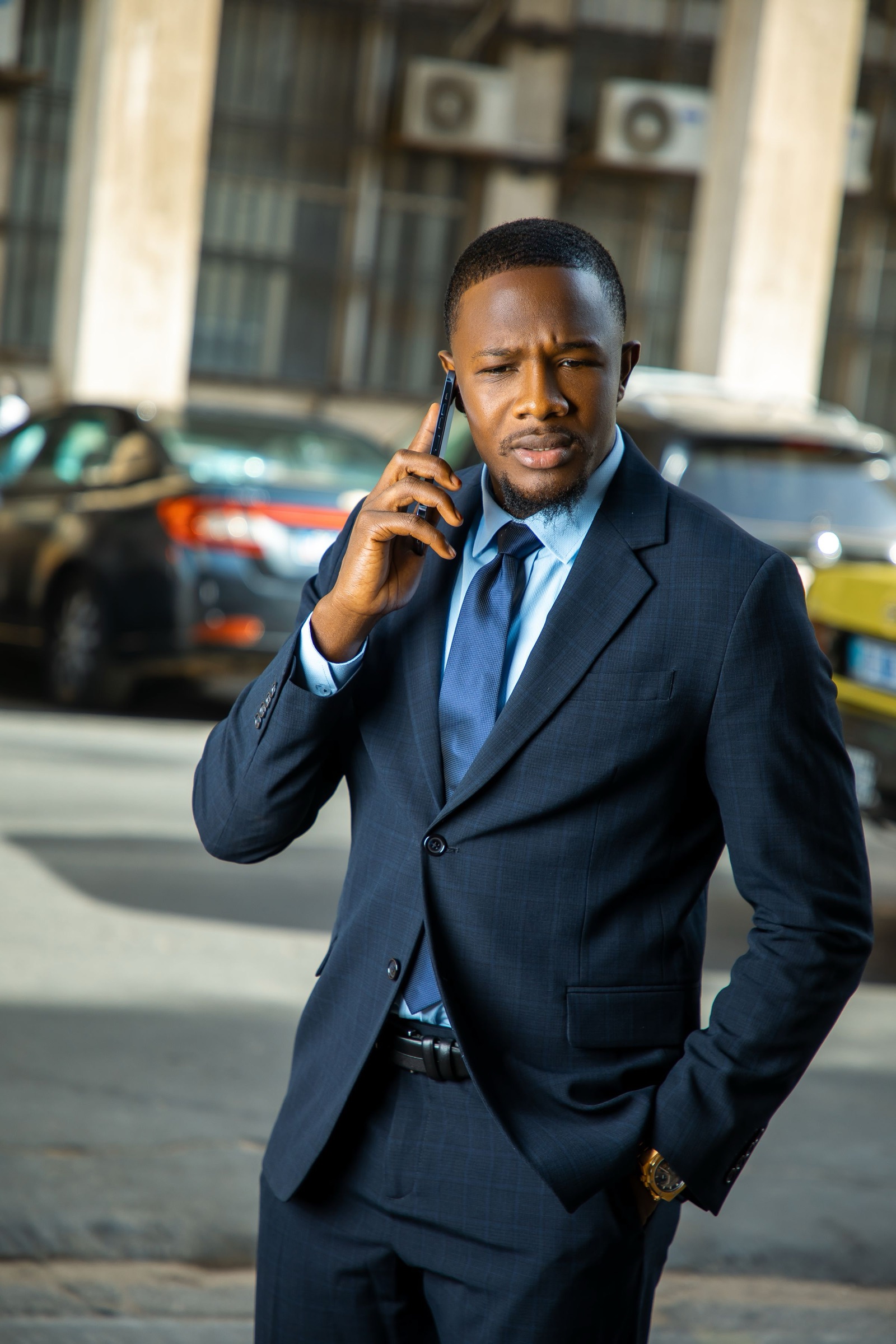 A businessman taking a call on a West African city street