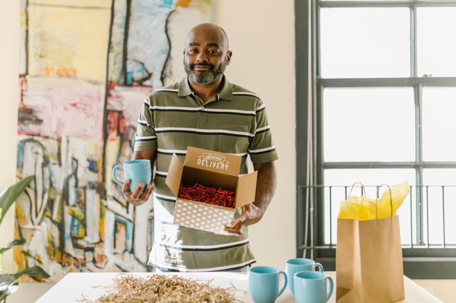 A small-business owner packing a branded delivery box at his workbench