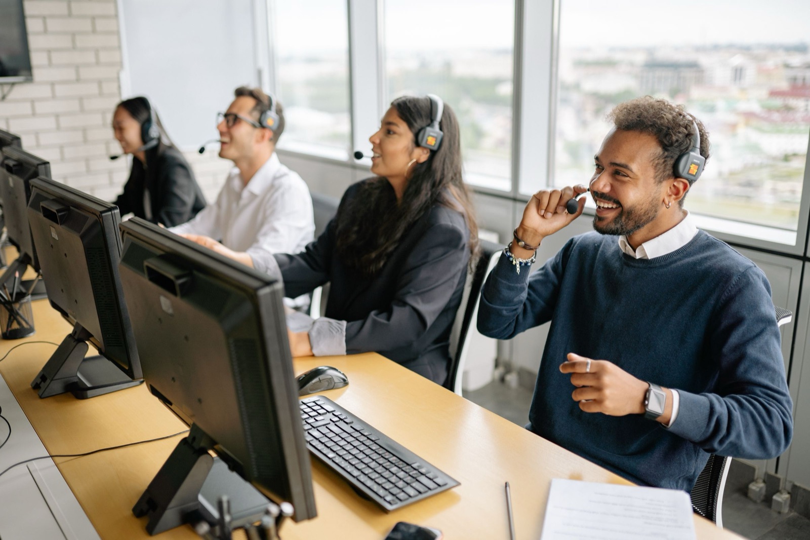 A support team on headsets at a row of desks, taking calls